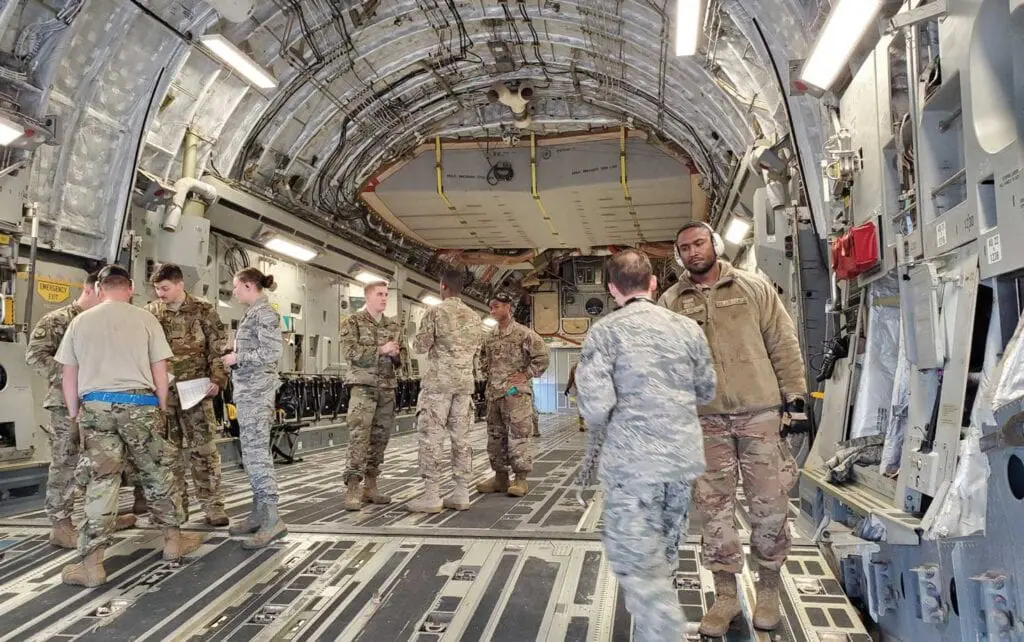 A group of people standing inside of an airplane.