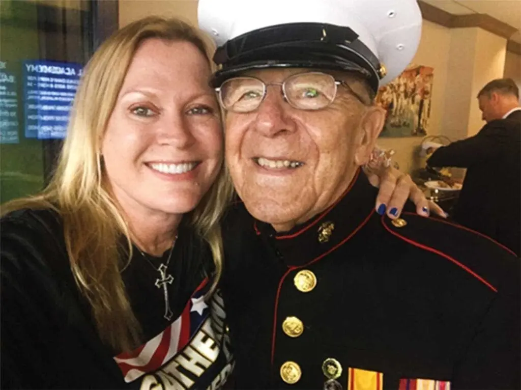 A man in uniform and woman posing for a picture.