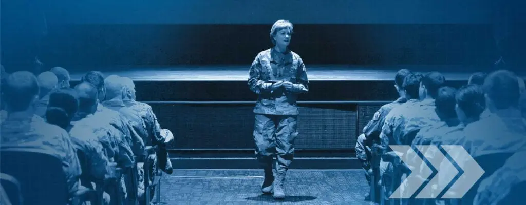 A woman in military fatigues is standing on the ground.