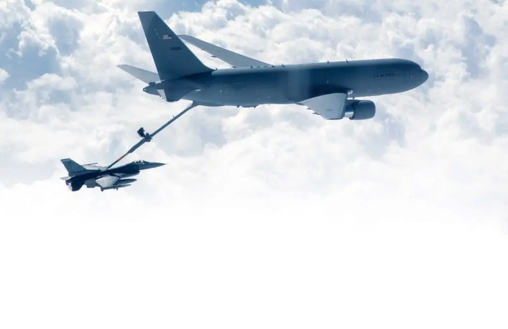 A plane flying in the sky with another plane behind it.