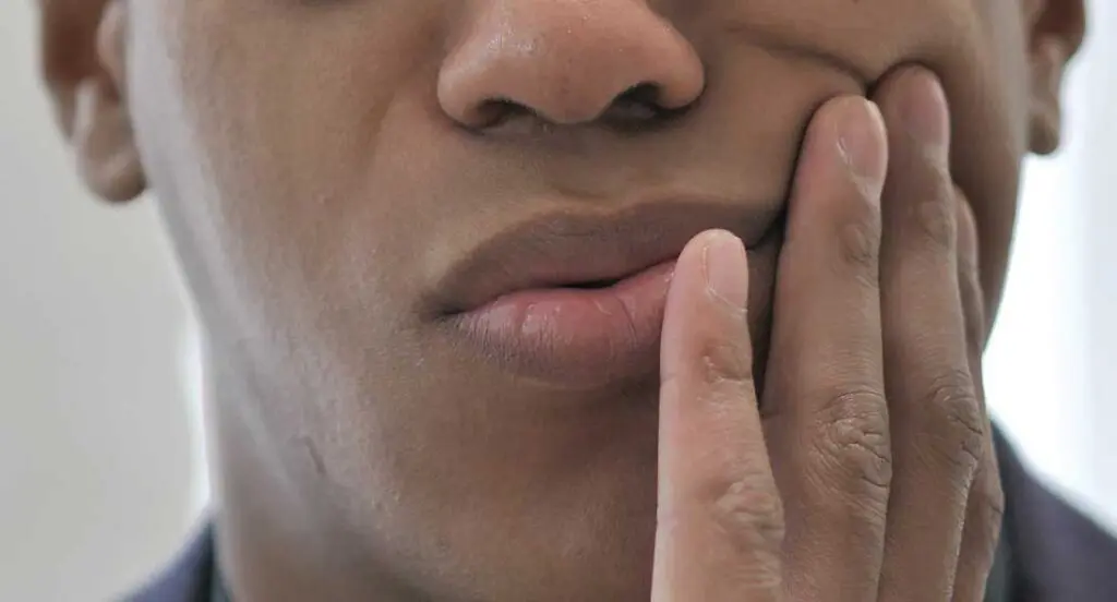 A person with their hand on his face