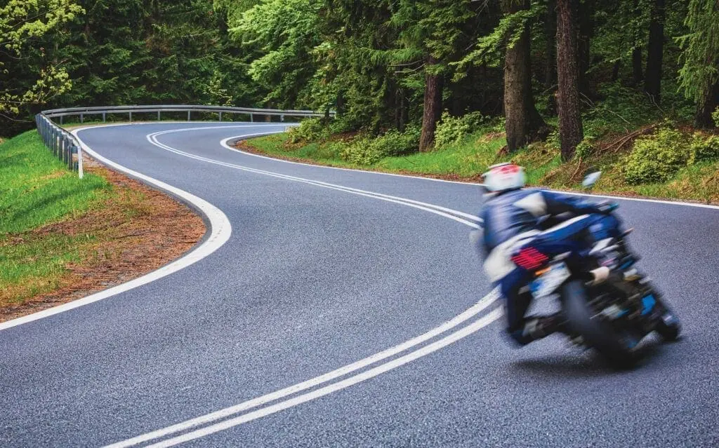 A person on a motorcycle riding down the road.