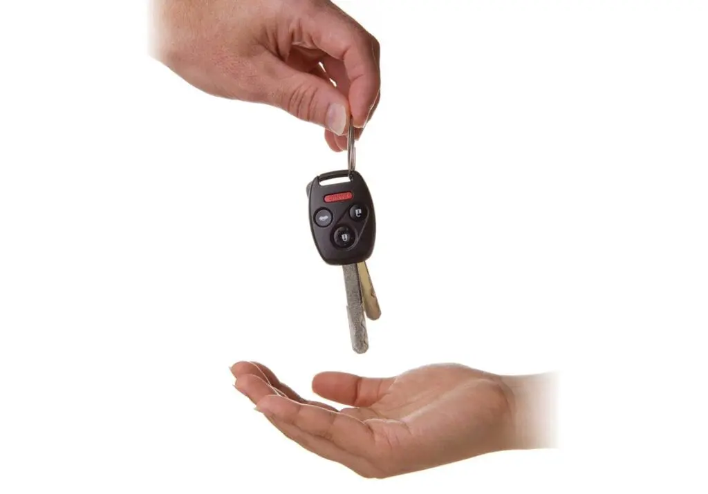 A person is handing another person keys over them.