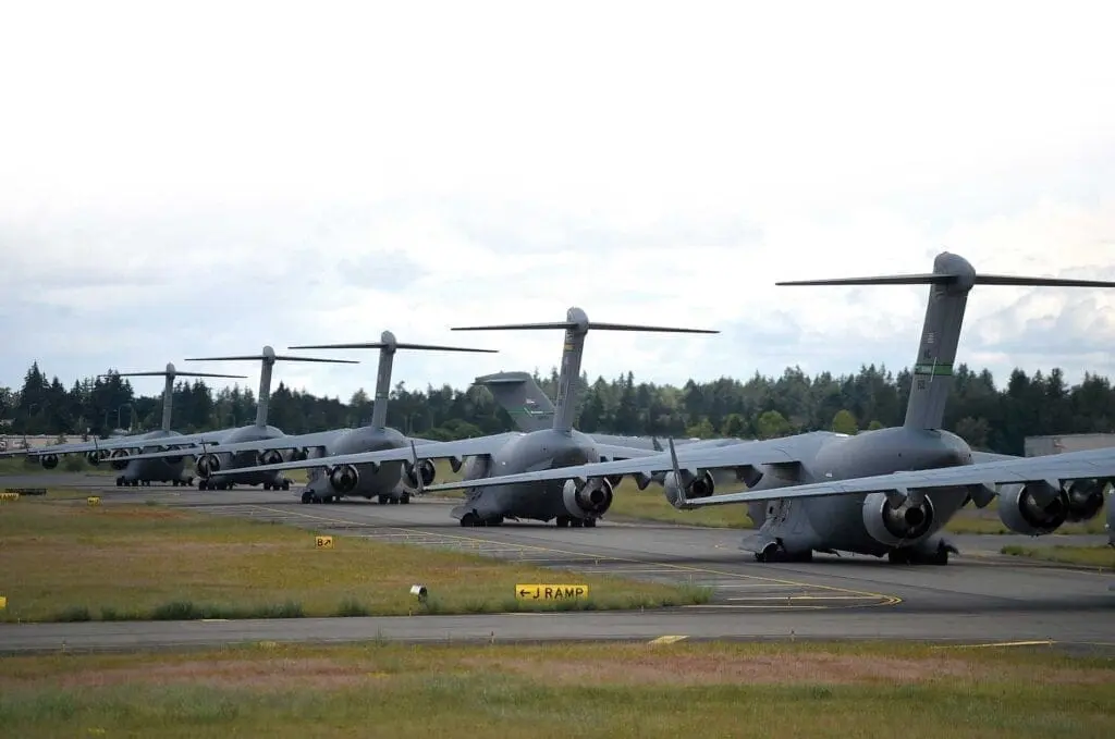 A group of military planes parked on the runway.