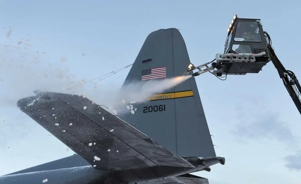 A jet fighter plane being sprayed with water.