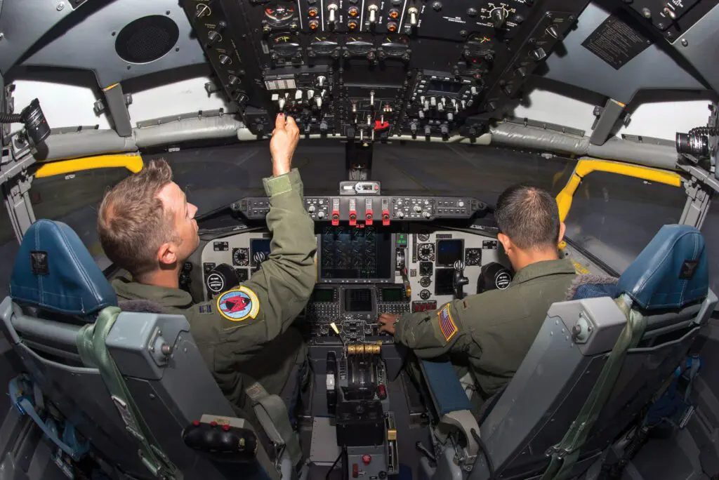 Two pilots are in the cockpit of a plane.