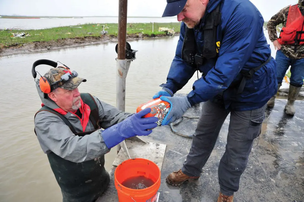 A man in blue gloves is holding something