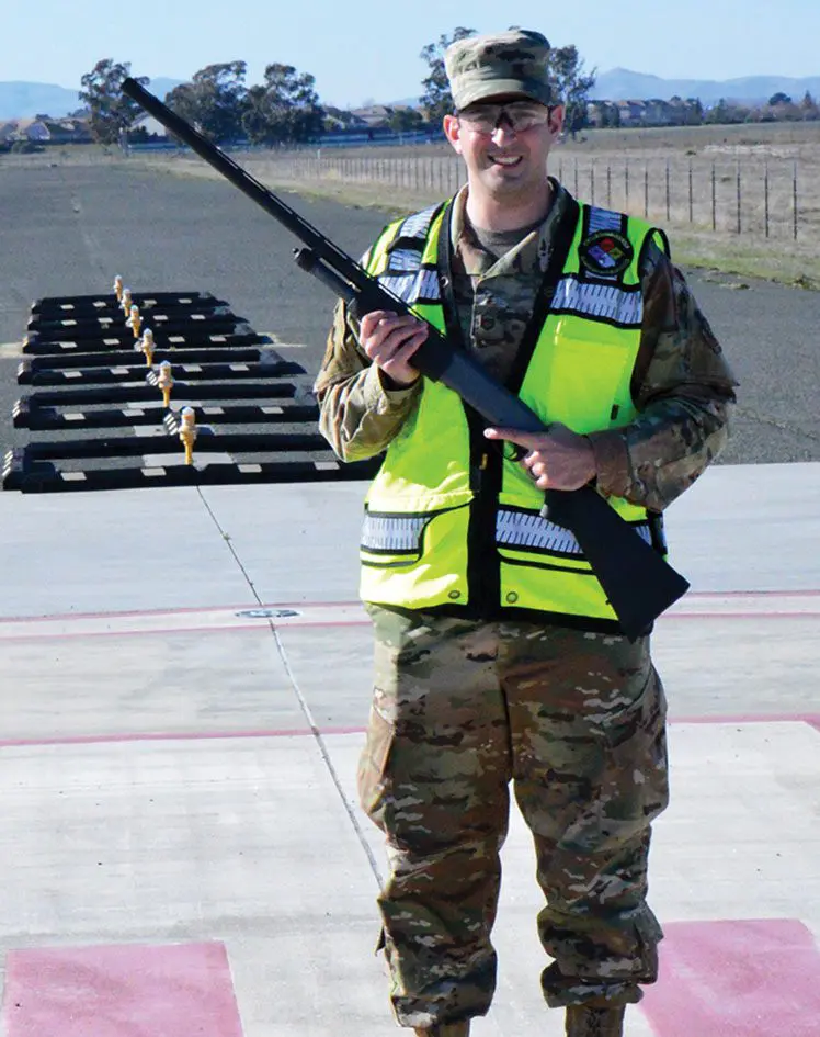 A man in military uniform holding a rifle.