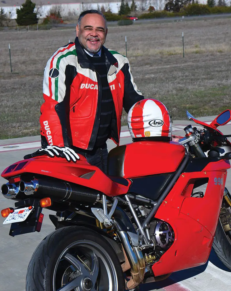 A man in red jacket sitting on motorcycle.