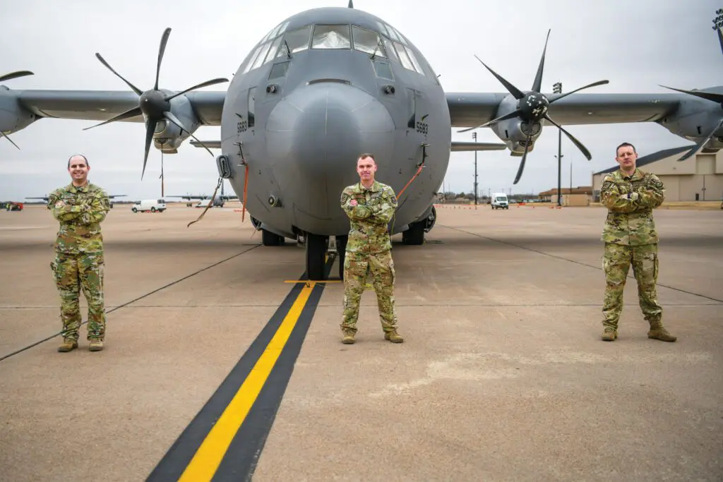 A man in military uniform standing next to an airplane.