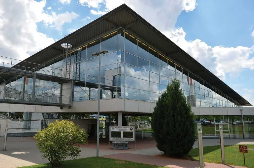 A building with glass windows and a tree in front of it.