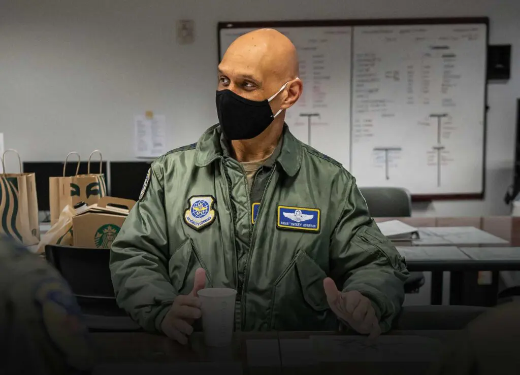 A bald man in an air force uniform wearing a mask.