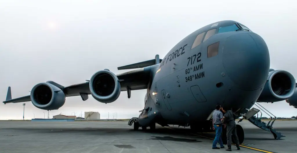 A large military plane sitting on top of an airport runway.