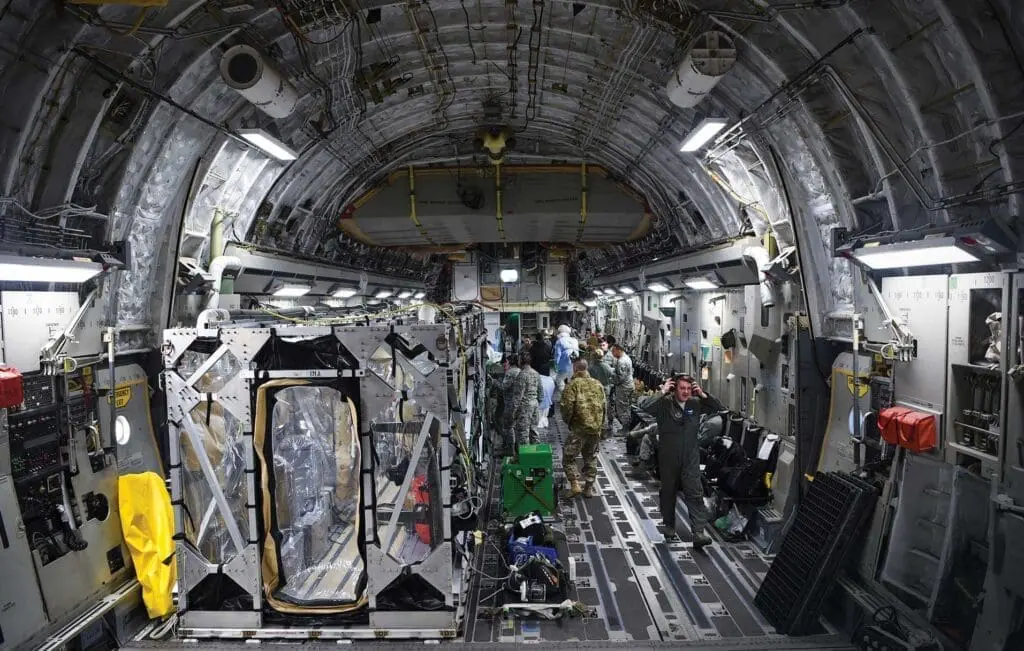 A group of people standing inside of an airplane.