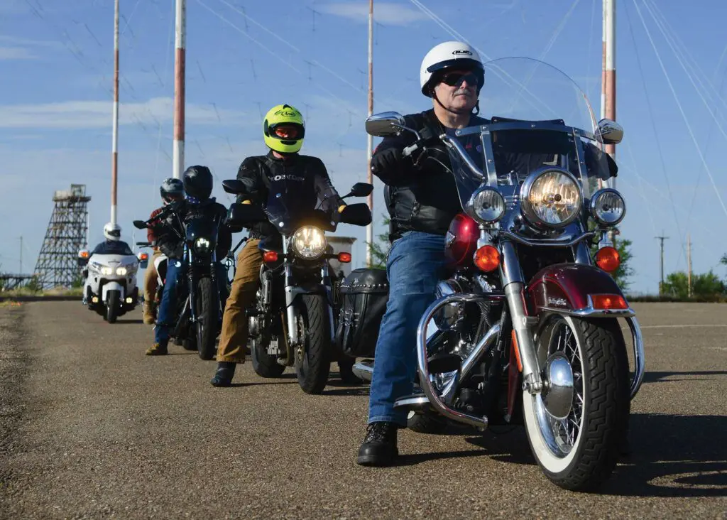 A group of people riding motorcycles on the road.