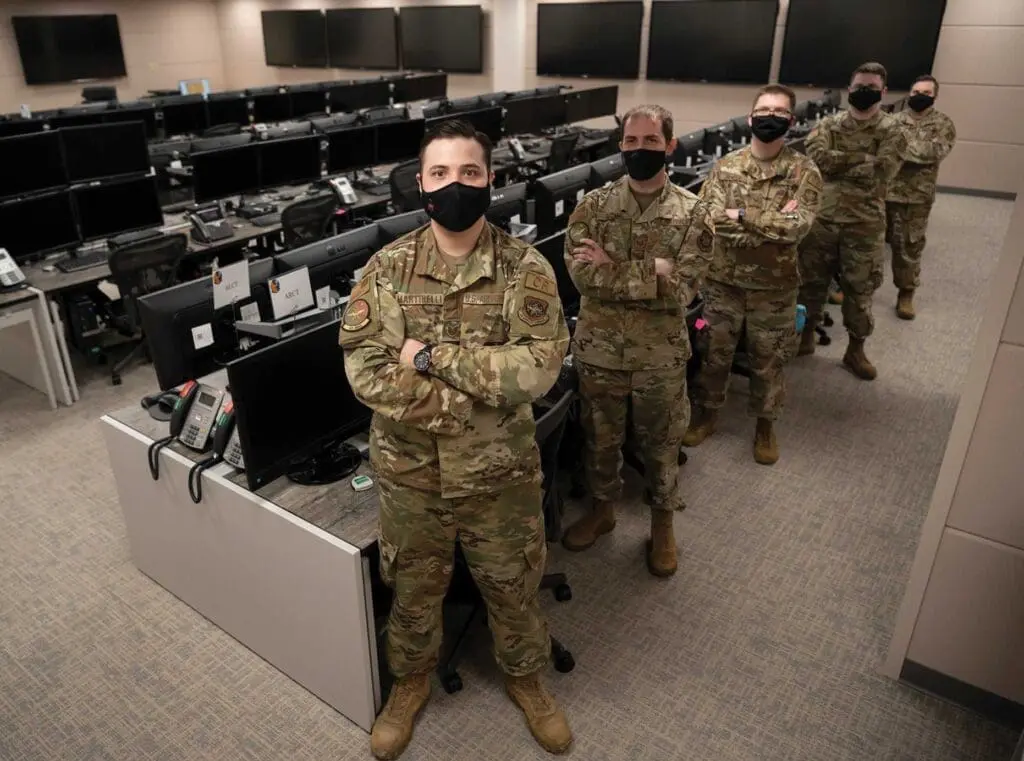 A group of soldiers standing in front of computers.