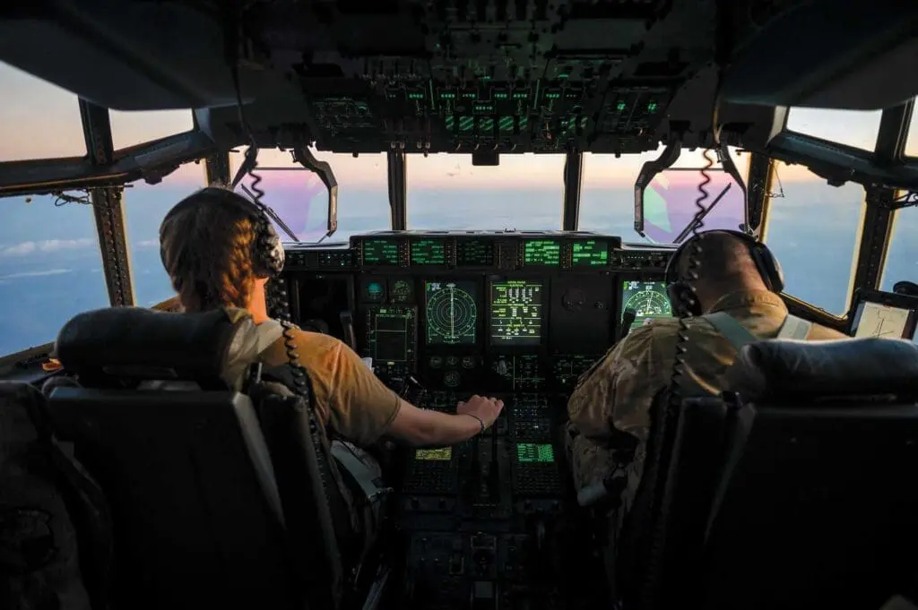 Two pilots are flying a plane in the sky.