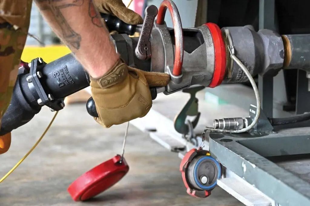 A person wearing gloves and working on a machine.