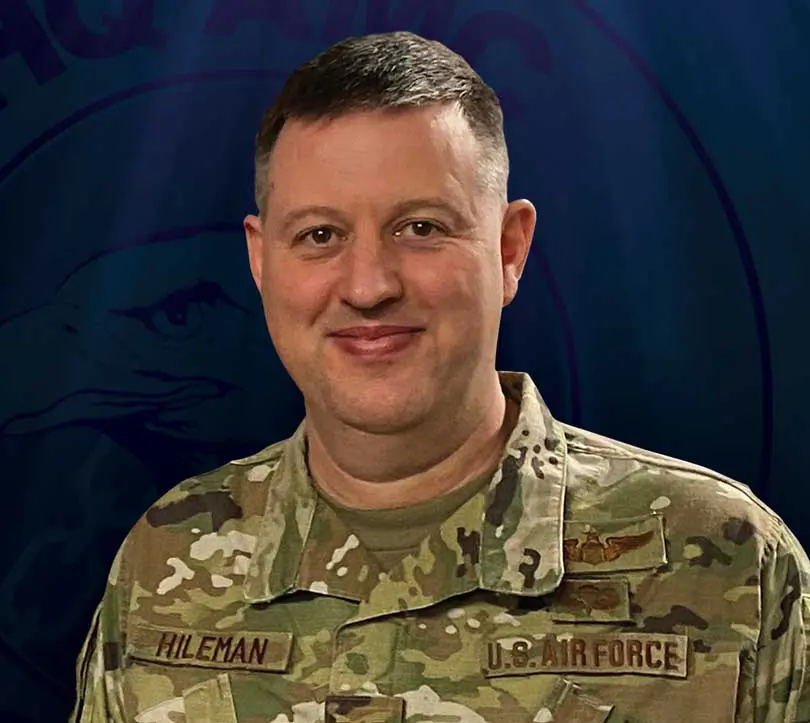 A man in military uniform with two patches on his chest.