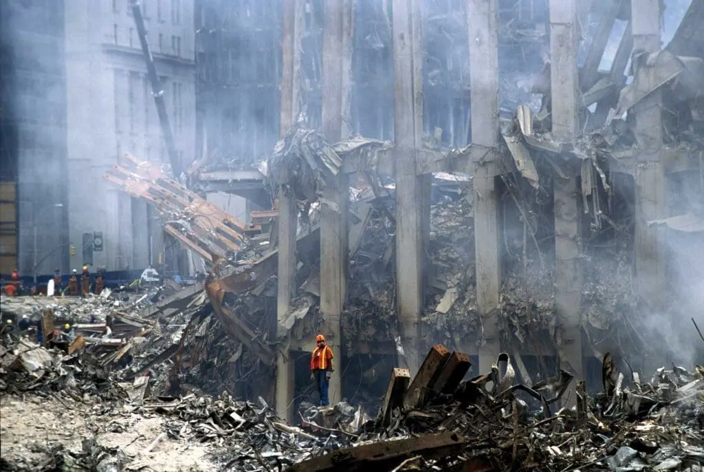A man standing in the middle of rubble.