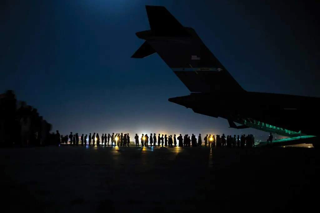 A large group of people standing on top of an airport runway.