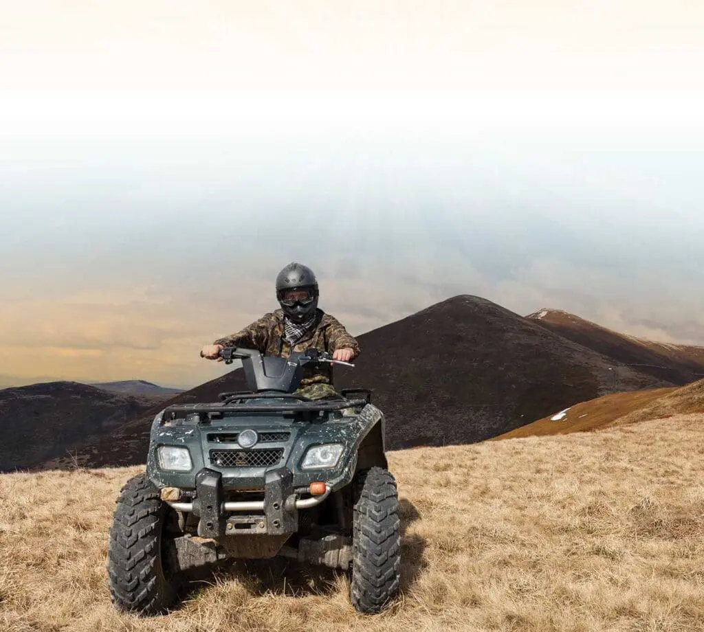 A man riding on the back of an atv.