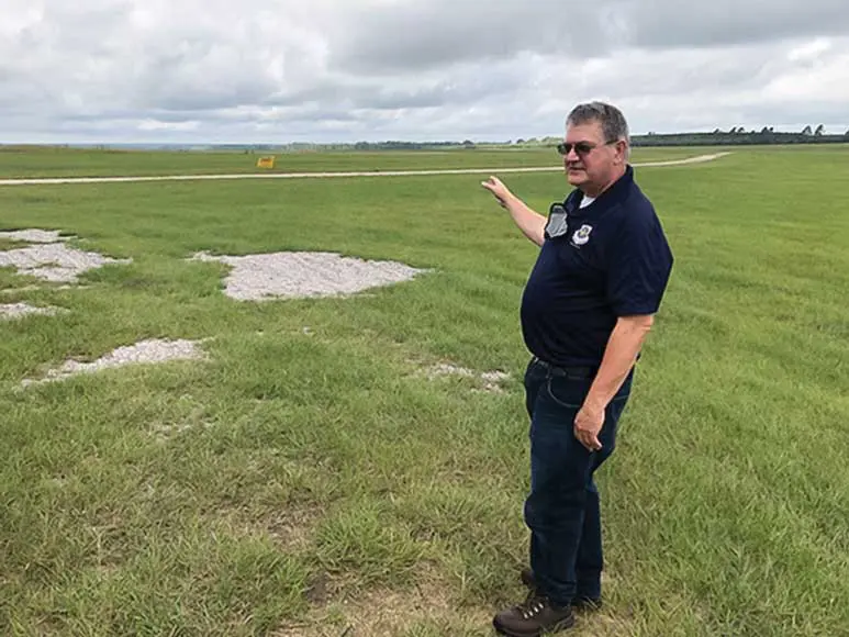 A man standing in the middle of an open field.