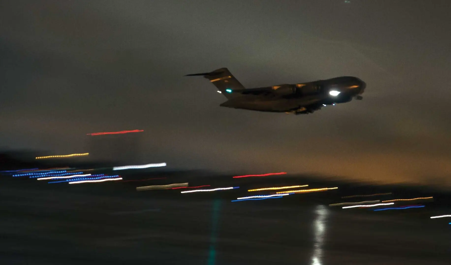 A large airplane flying in the sky at night.