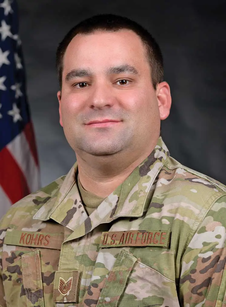 A man in military fatigues and a flag.