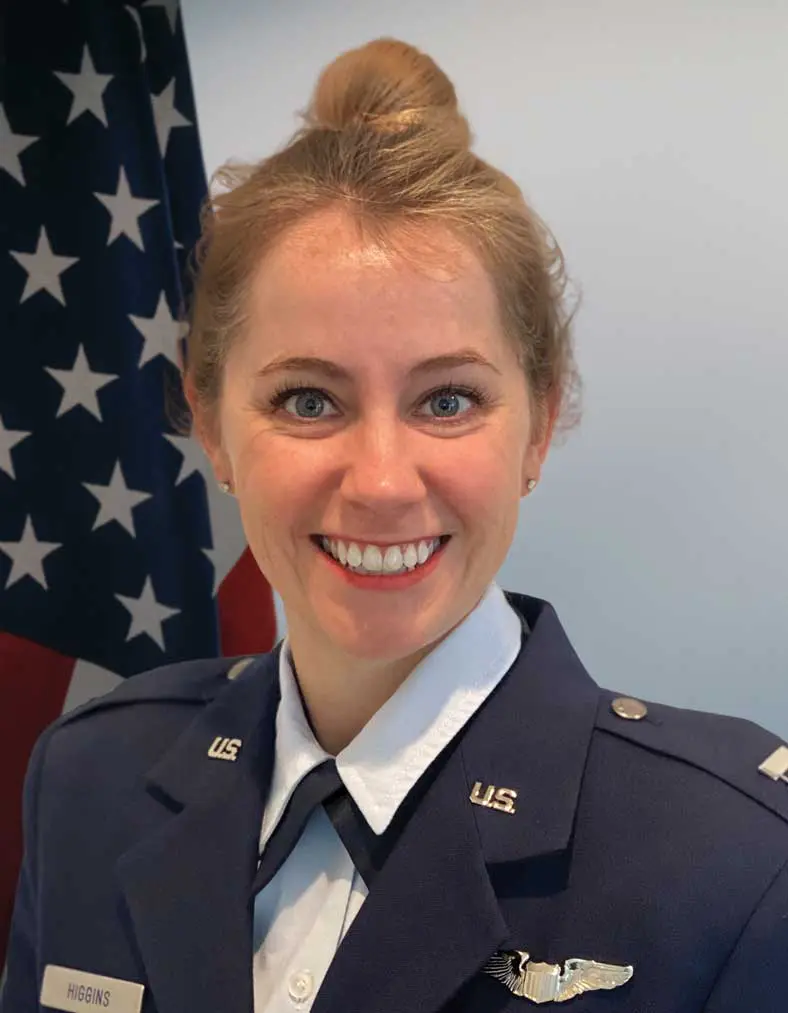 A woman in uniform smiling for the camera.