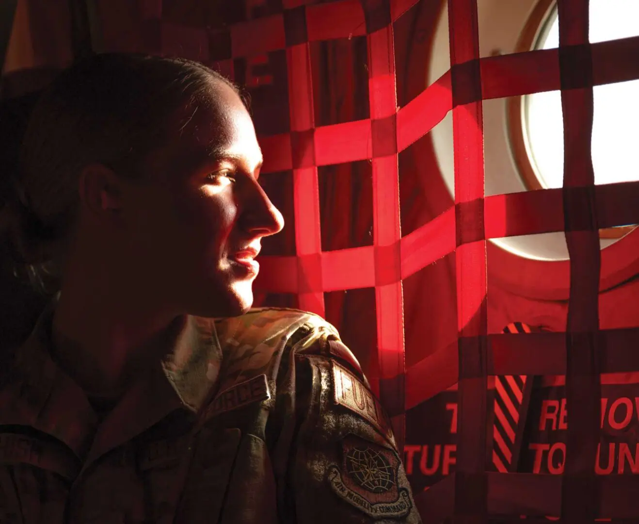 A soldier is looking out of the window.
