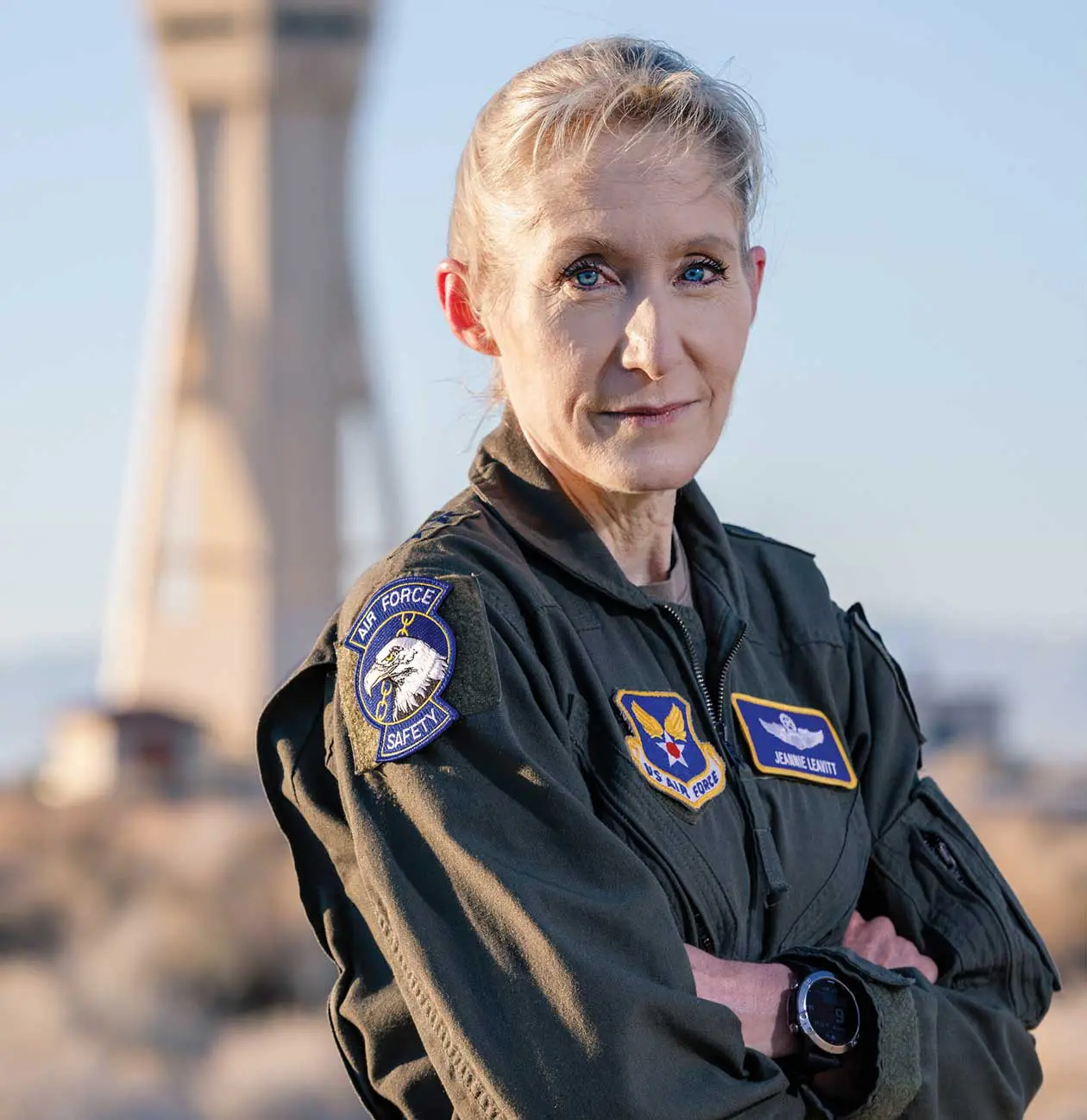 A woman in an air force uniform standing next to some rocks.