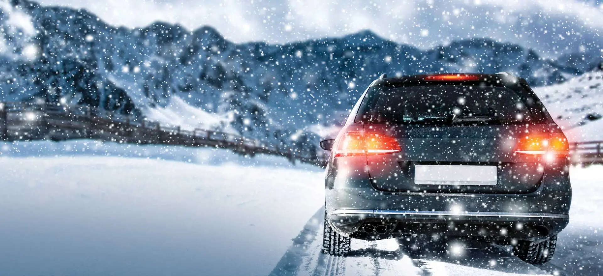 A car driving down the road in snow.