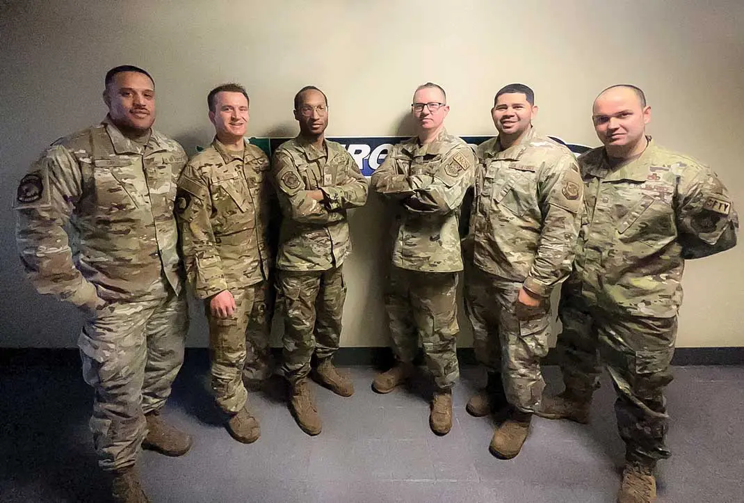 A group of soldiers standing in front of a wall.