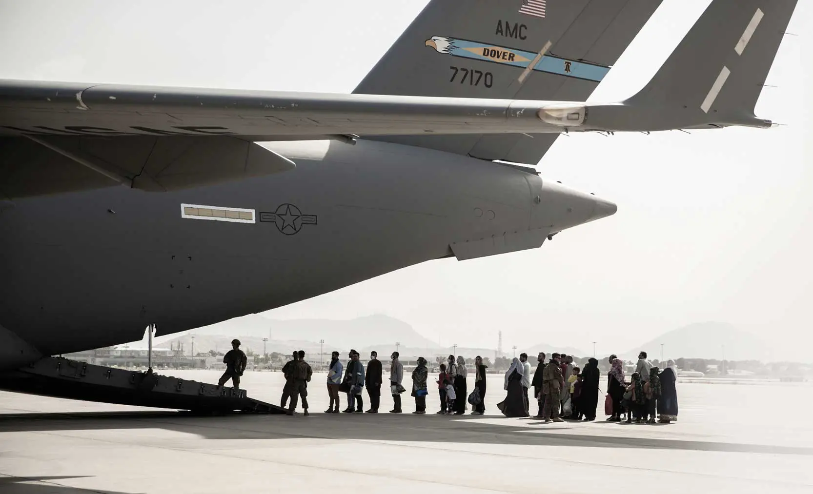 A group of people standing around an airplane.