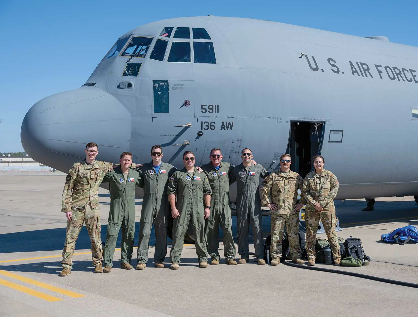 A group of men standing in front of an airplane.