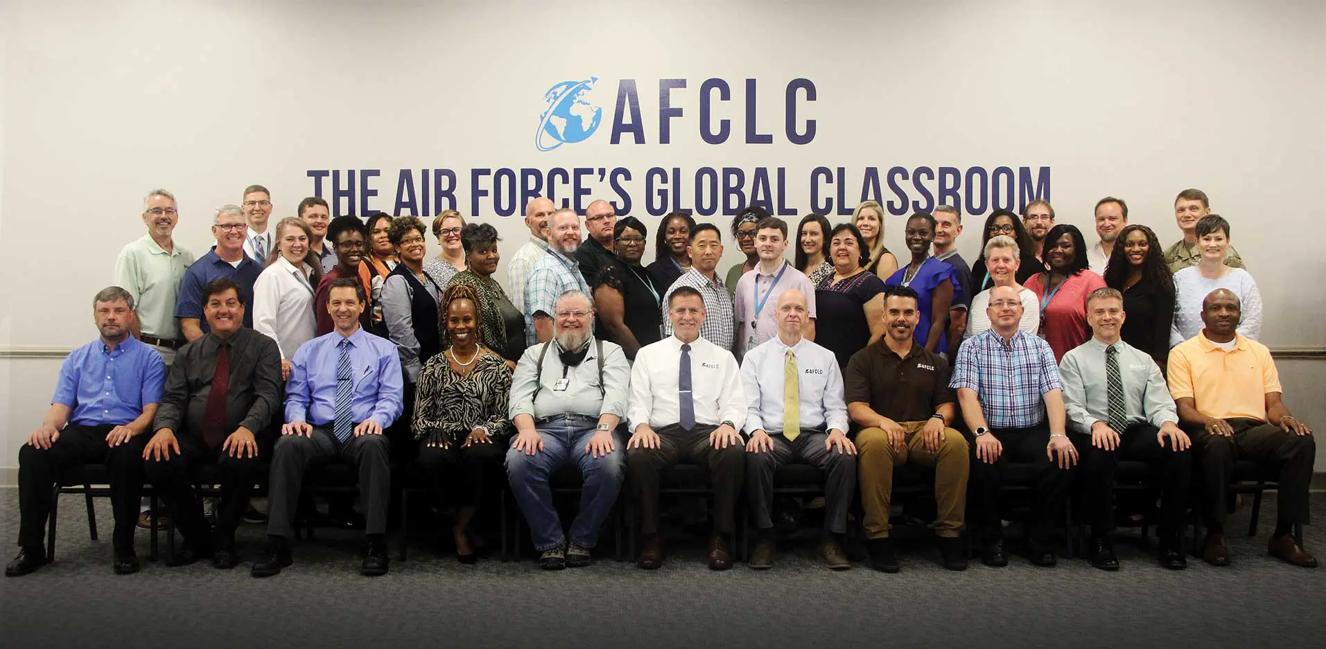 A group of people that are standing in front of a wall.
