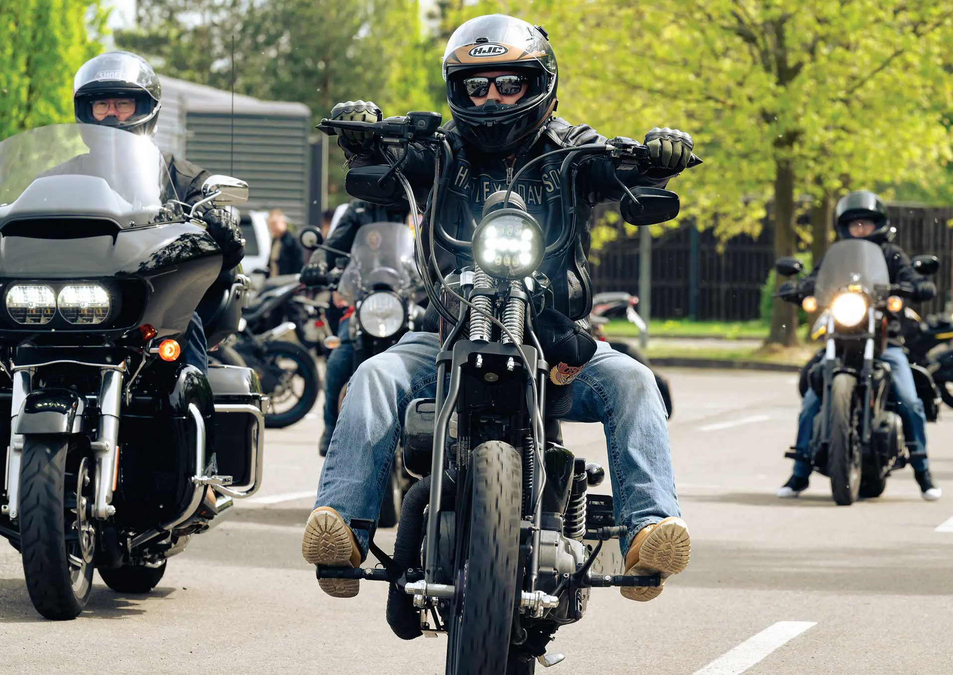 A group of people riding motorcycles on the street.