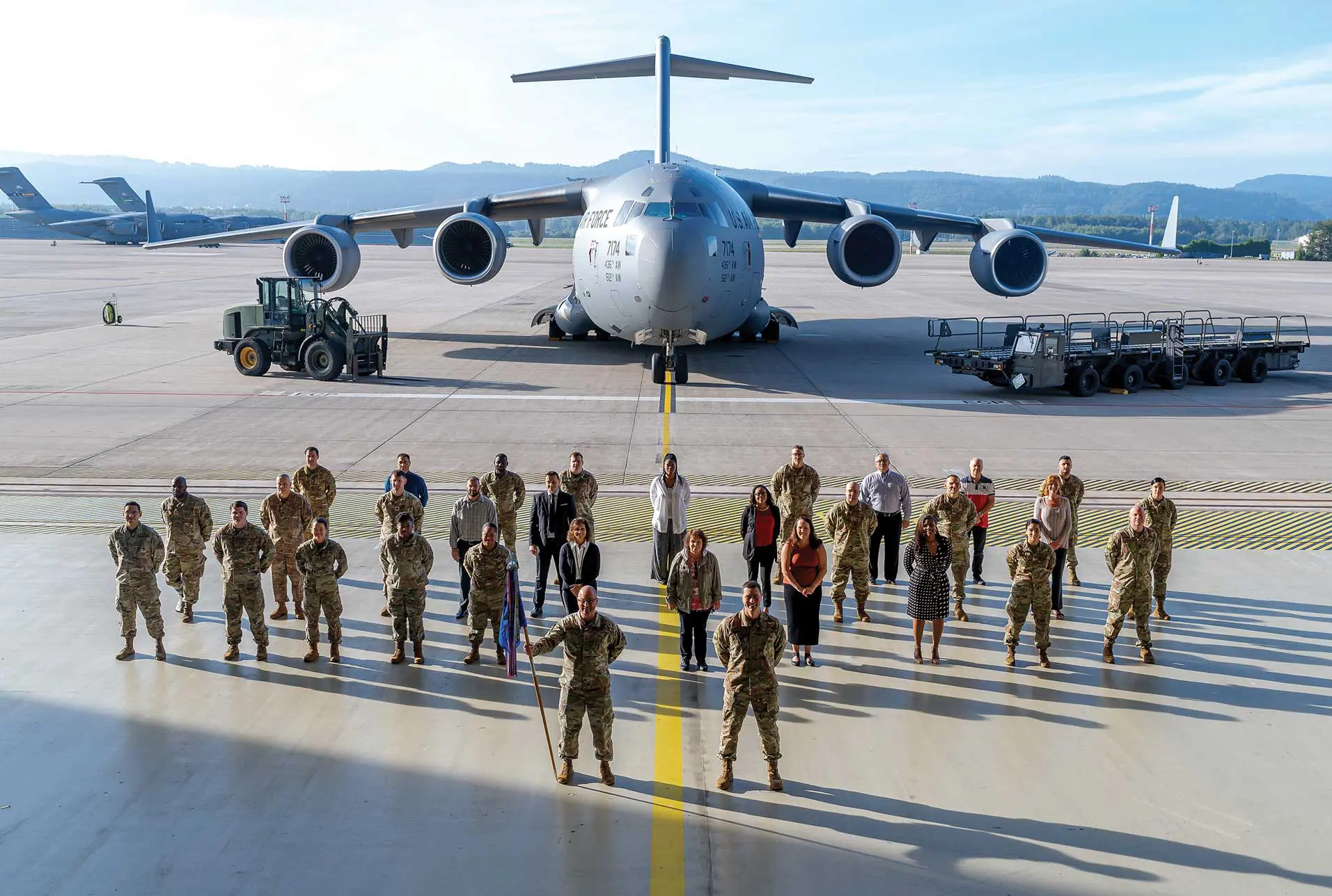 A group of people standing in front of an airplane.