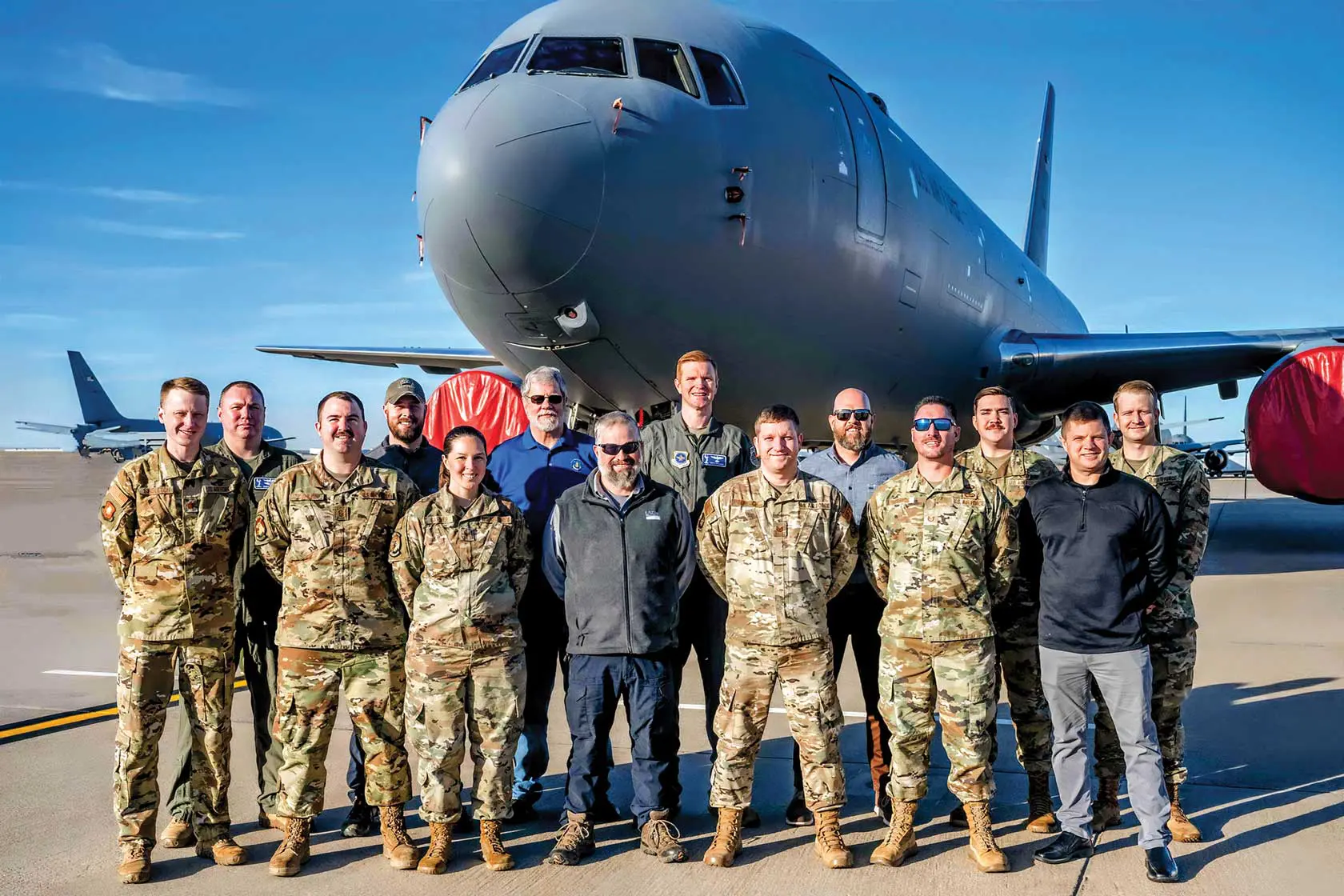 A group of people standing in front of an airplane.