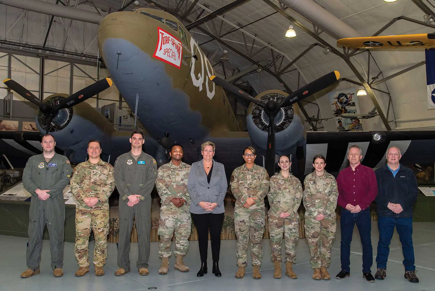 A group of people standing in front of an airplane.