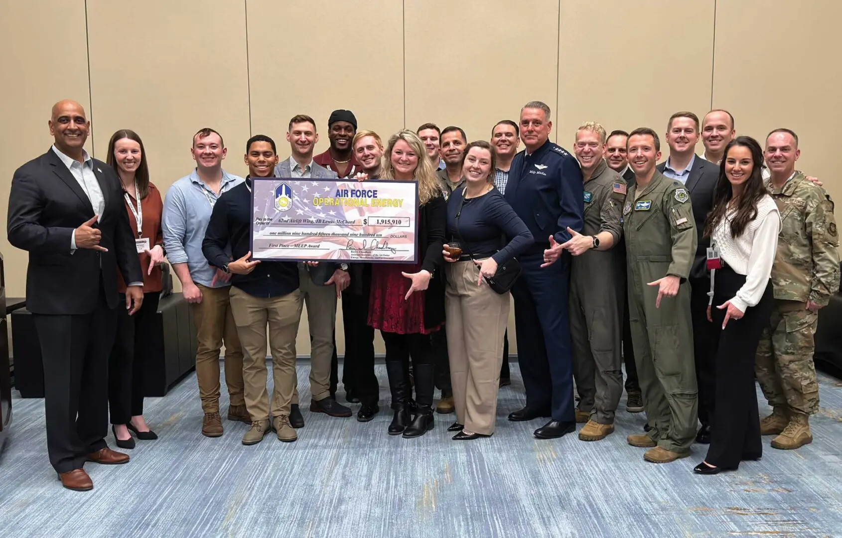 A group of people standing around each other holding a large check.