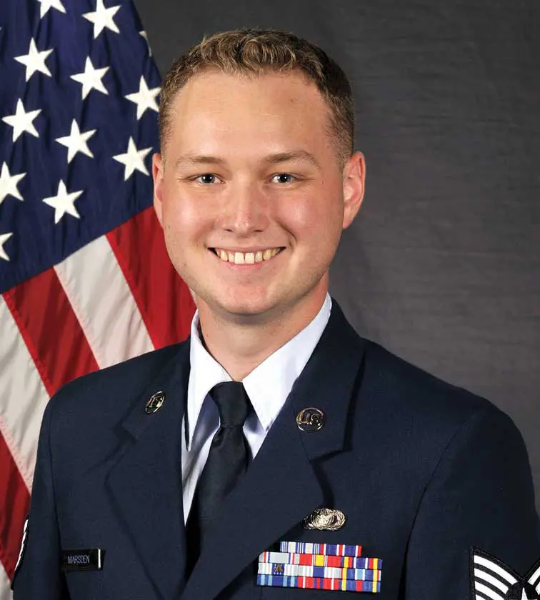 A man in uniform standing next to an american flag.