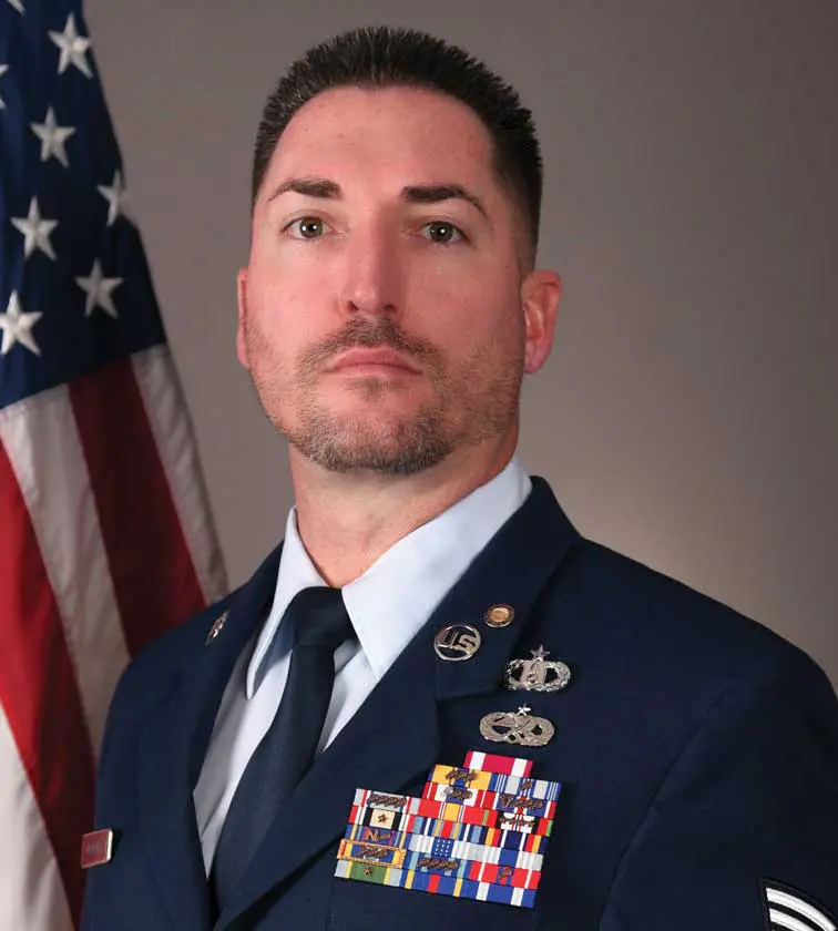 A man in uniform with an american flag behind him.