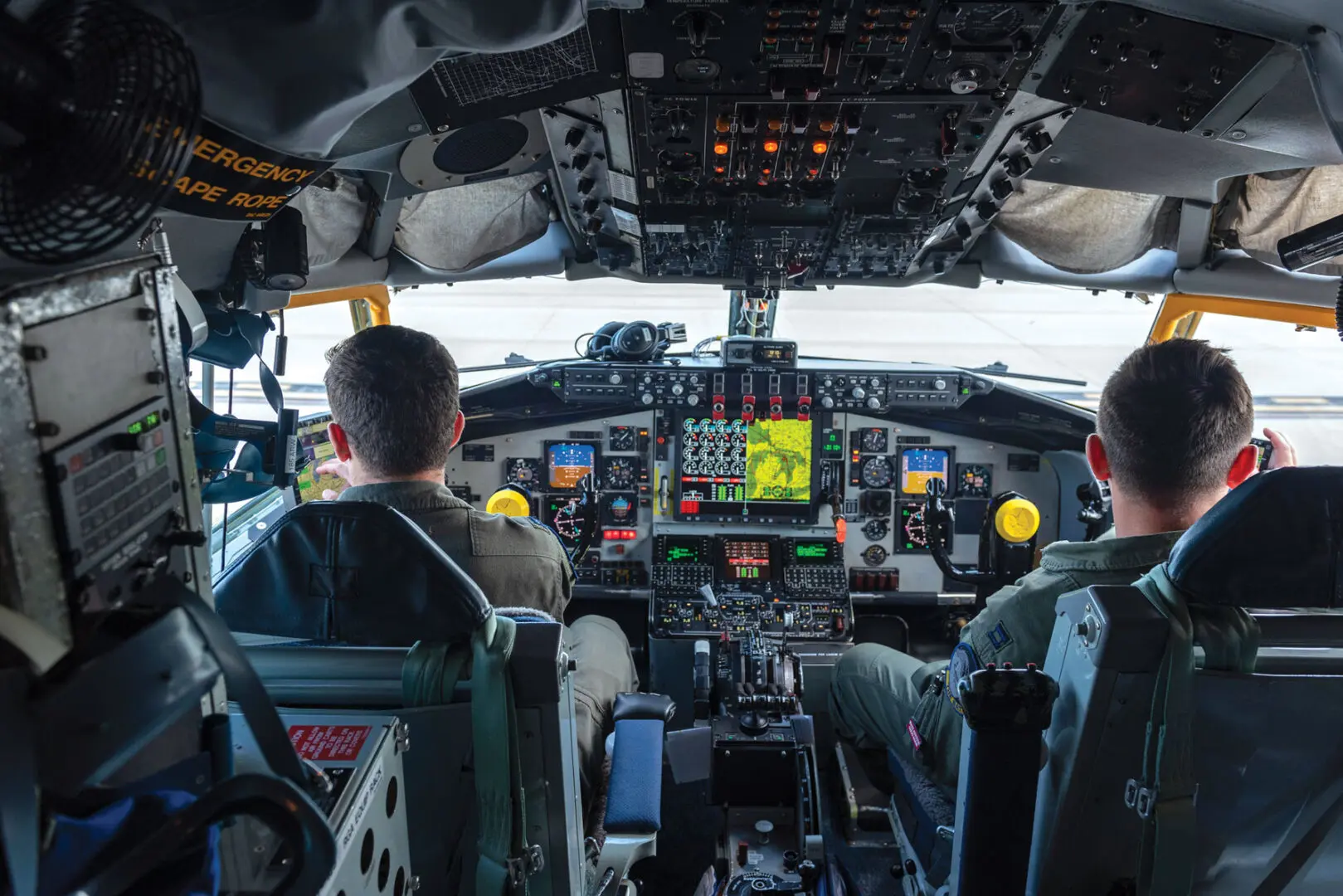 Two Air Force pilots sit in the cockpit of an airplane, preparing for takeoff.