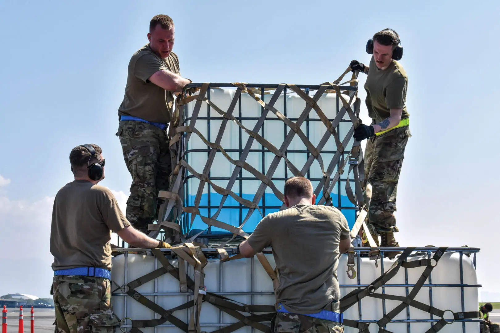 Four airmen secure a load with straps during the Air Mobility Team Rodeo at Joint Base Pearl Harbor-Hickam, Hawaii.