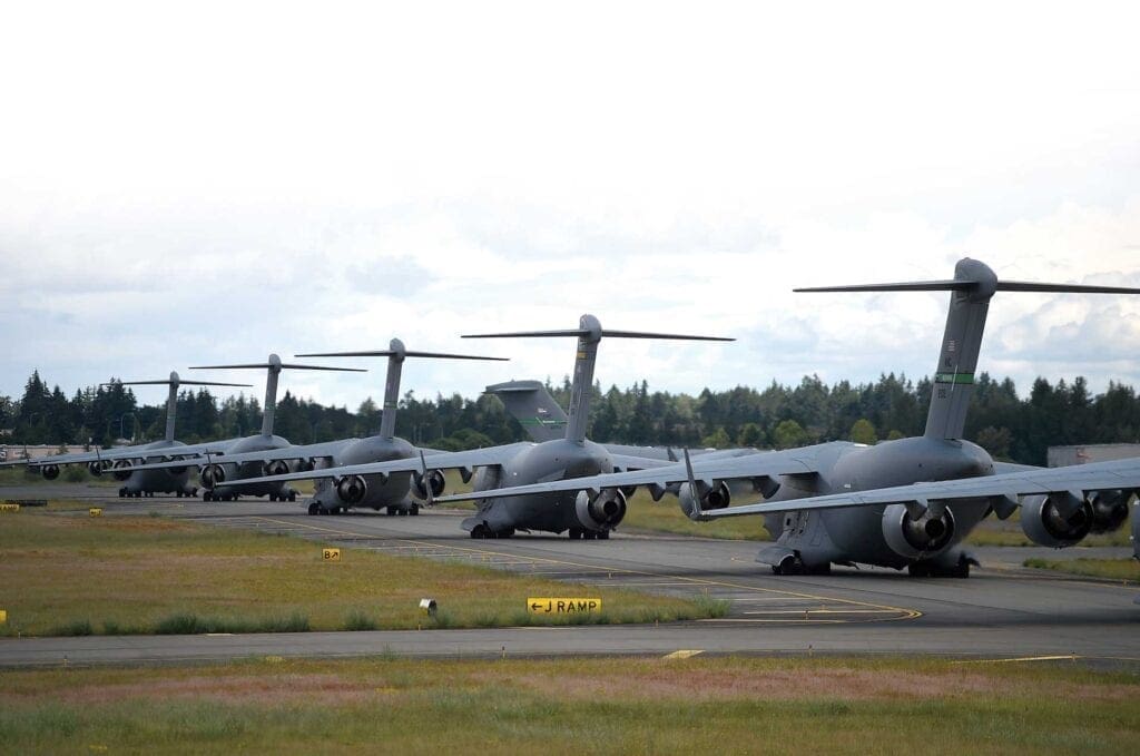 A group of military planes parked on the runway.