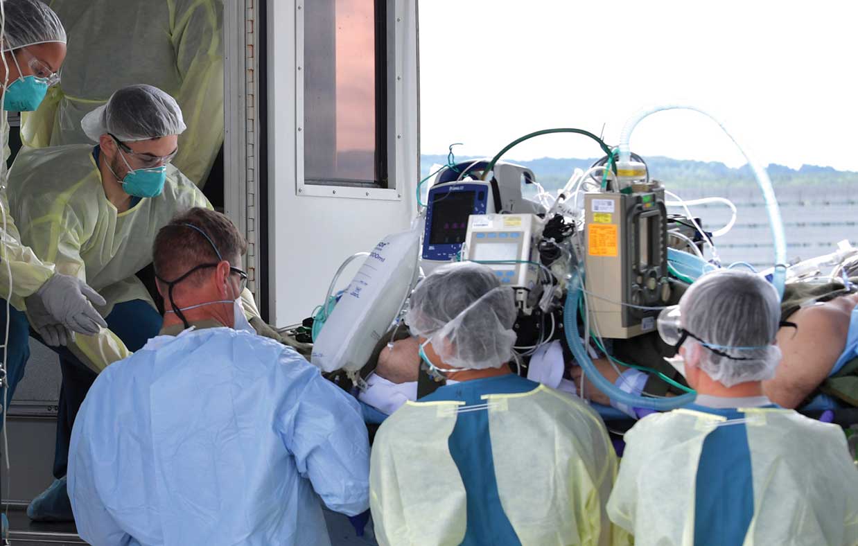 A group of doctors and nurses are gathered around.