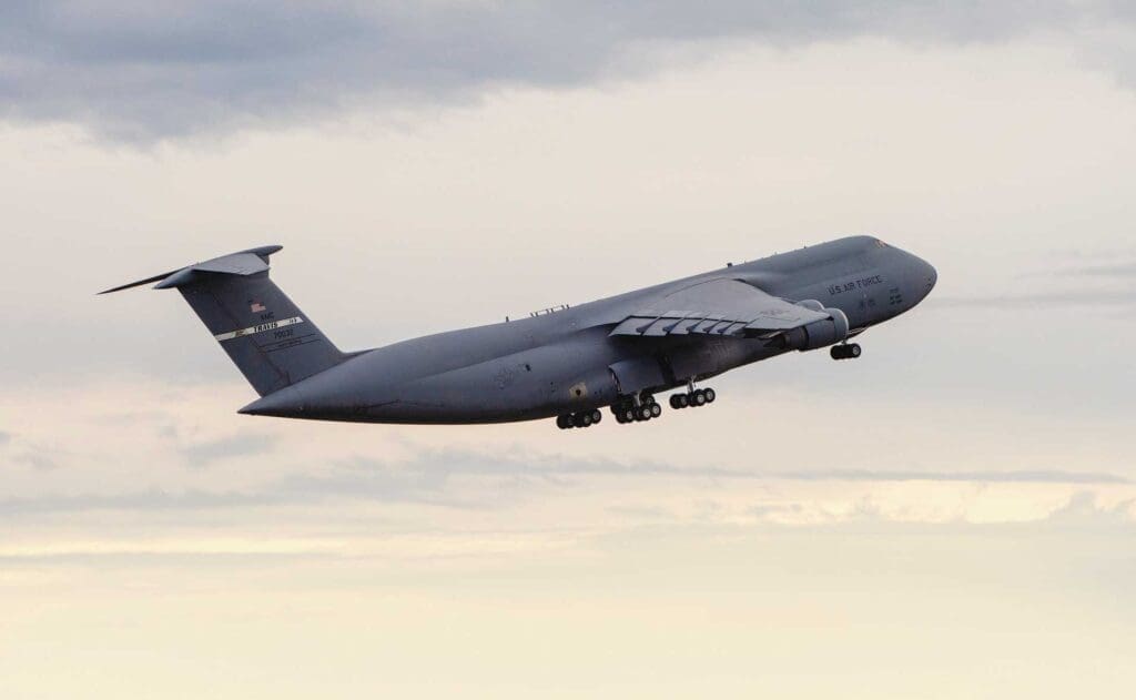 A large military plane flying in the sky.