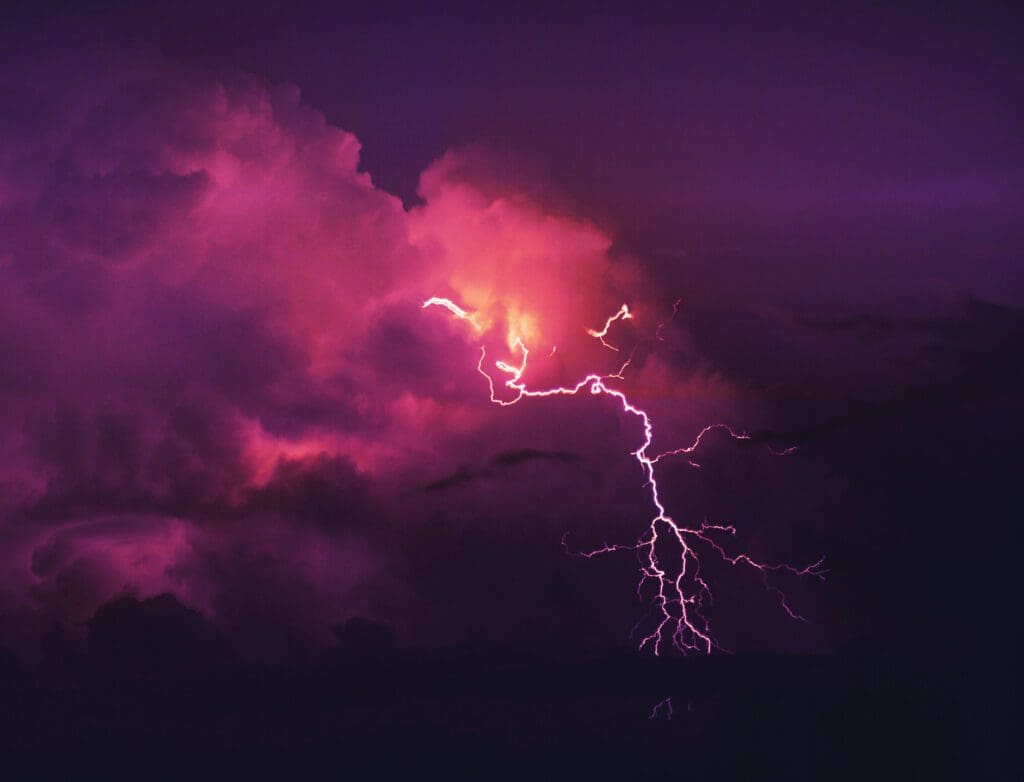 A purple cloud with lightning in the sky.